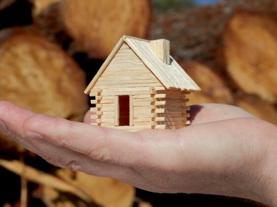 mini domček z dreva položený na dlani